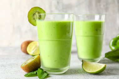 Açık arkaplanda sağlıklı yeşil meyve suyu bardakları
