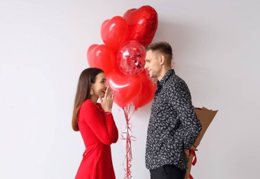 Genç bir adam sevgililer günü için arka planda sevgilisini selamlıyor.