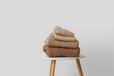 Işık duvarının yanındaki masada bir yığın sıcak bej kazak.