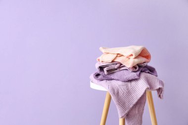 Leylak duvarının yanındaki masada kalın kazaklar var.