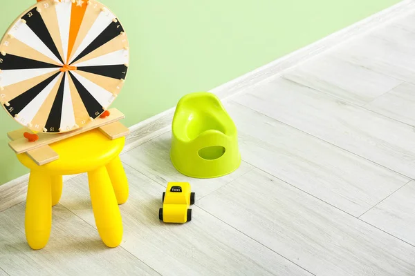 Töpfchen Spielzeugauto Und Tisch Mit Glücksrad Auf Grauem Holzboden — Stockfoto