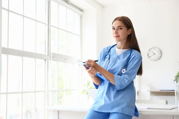 Médico Feminino Escrevendo Área Transferência Perto Mesa Clínica — Fotografia de Stock