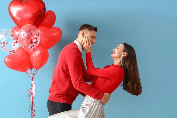 色の背景に風船で幸せな若いカップル バレンタインデーのお祝い — ストック写真