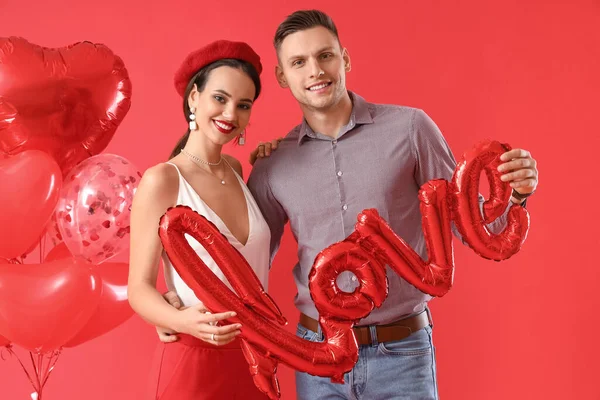 Jovem Casal Feliz Com Balão Forma Palavra Amor Fundo Vermelho — Fotografia de Stock