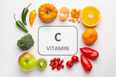 Metin C VITAMIN ve beyaz arkaplanda sağlıklı ürünler