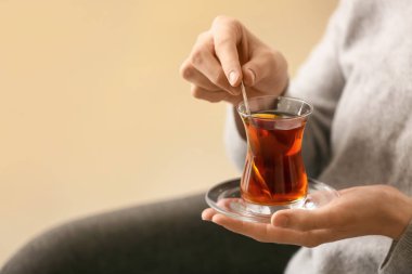 Evde Türk çayı içen kadın, yakın plan.