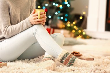 Noel arifesinde evinde sıcak çoraplı bir kadın.