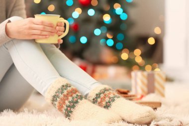 Noel arifesinde evinde sıcak çoraplı bir kadın, yakın plan.