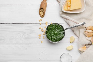 Lezzetli pesto sosu ve hafif ahşap arka planda malzemeler.