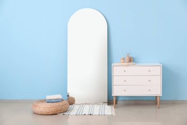 Mavi duvarın yanındaki çekmecelerin büyük aynası ve sandığı.