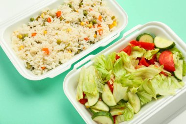 Sebzeli pilav ve yemek kutusunda salata karışımı. Renkli arka plan, yakın plan.