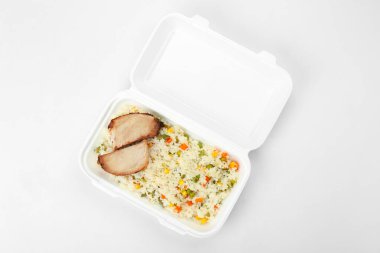 Sebzeli pilav ve arka planda beslenme çantasında tavuk filetosu.