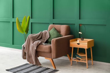 Oda duvarının yanında ekoseli ve masalı rahat bir koltuk.