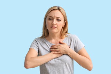 Olgun bir kadın, arka planda göğsünde rahatsızlık hissediyor. Kanser farkındalığı kavramı