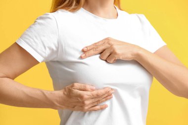 Olgun bir kadın, arka planda göğsünde rahatsızlık hissediyor. Kanser farkındalığı kavramı