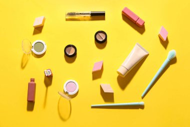 Sarı arka planda dekoratif kozmetik ürünler