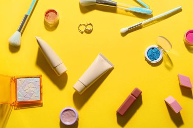 Sarı arka planda dekoratif kozmetik ürünler