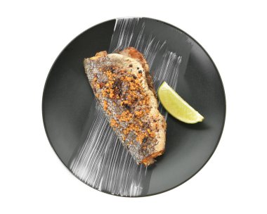 Lezzetli levrek ve beyaz arka planda limon tabağı.