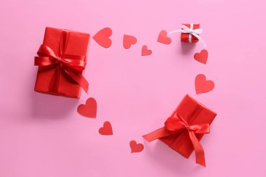 Kalp şeklinde çerçeve pembe arka planda Sevgililer Günü hediyelerinden yapılmıştır.