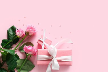 Sevgililer günü hediyeleri, gül buketi ve renk arkaplanda pullar.