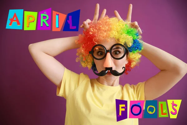 Funny woman with party decor for April Fools' Day on color background