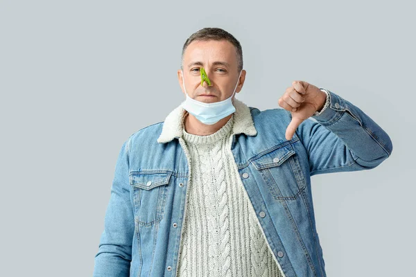 Kranker Älterer Mann Mit Wäscheklammer Auf Der Nase Daumen Nach — Stockfoto