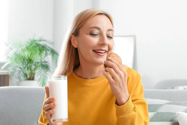 Ώριμη Γυναίκα Πίνει Γάλα Και Τρώει Μπισκότα Στο Σπίτι — Φωτογραφία Αρχείου