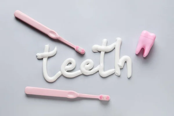 Zahnbürsten Zahnseide Und Mit Zahnpasta Geschriebenes Wort Teeth Auf Grauem — Stockfoto