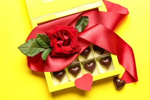 Box Mit Leckeren Herzförmigen Bonbons Und Rose Auf Gelbem Hintergrund — Stockfoto