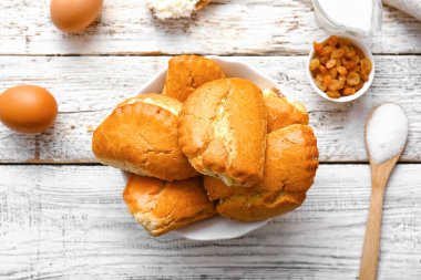 Beyaz ahşap arka planda süzme peynirli bir kase lezzetli sochniki.