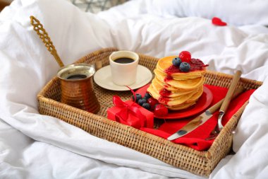 Tatlı bir kahvaltı tepsisi ve yumuşak yatakta sevgililer günü hediyesi.