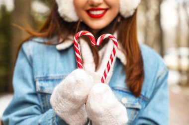 Eldivenli genç bir kadın elinde şeker kamışı, yakın plan.