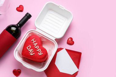 Lezzetli bento kekiyle plastik beslenme çantası ve pembe arka planda Sevgililer Günü için mektup.