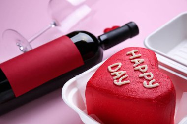 Pembe arka planda Sevgililer Günü için lezzetli bento kekiyle plastik beslenme çantası.