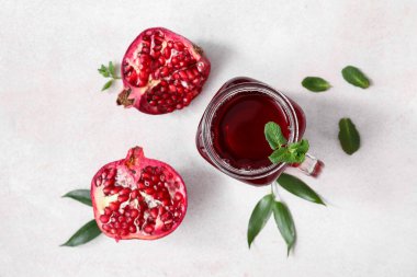 Mason kavanozu dolusu lezzetli nar suyu ve beyaz arka planda taze meyveler.