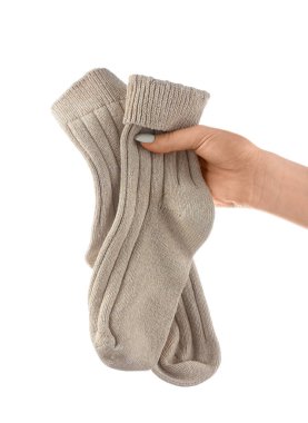 Beyaz arka planda bir çift çorap tutan kadın