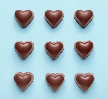 Mavi arka planda kalp şeklinde lezzetli şekerler.