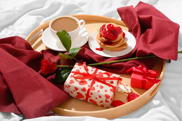 おいしい朝食と柔らかいベッドでバレンタインデーのプレゼントを持つ木製のトレイ — ストック写真
