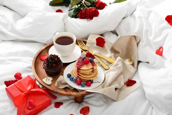 朝食付きの木製トレイ バラの花びら 柔らかいベッドの上でバレンタインデーのプレゼント — ストック写真
