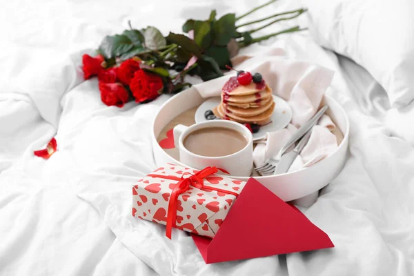 ベッドの上でバレンタインデーのためのおいしい朝食とギフトボックスでトレイ — ストック写真
