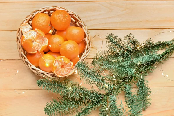 Wicker Bowl Tasty Tangerines Christmas Lights Fir Branches Wooden Background — Stock Photo, Image