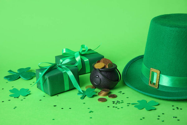 Горшок с монетами, подарочными коробками и шляпой лепрекона на зеленом фоне. Празднование Дня Святого Патрика