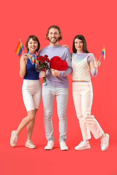 虹の旗 贈り物や色の背景に花を持つ男と2人の美しい女性 一夫多妻制とLgbtの概念 — ストック写真