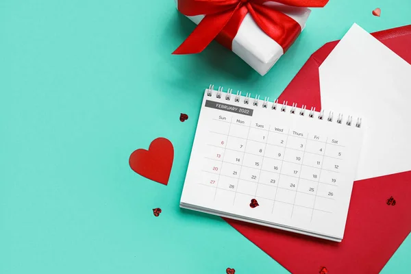 Kalender Mit Umschlag Geschenk Und Herzen Auf Türkisfarbenem Hintergrund Valentinstag — Stockfoto