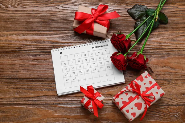 木の背景にバラや贈り物とカレンダー バレンタインデーのお祝い — ストック写真