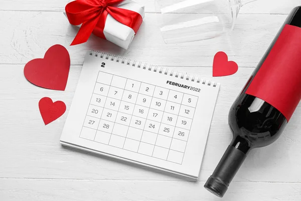 白の木製の背景にワイン ガラス 贈り物や心のボトルとカレンダー バレンタインデーのお祝い — ストック写真