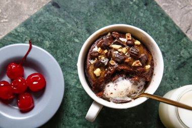 Gri arka planda lezzetli çikolatalı brownie bardağı.