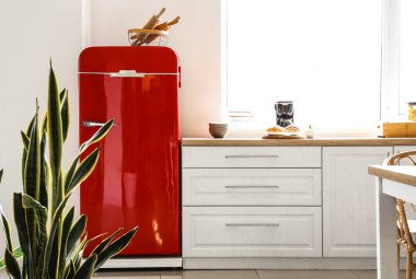 Kırmızı buzdolabı ve beyaz tezgahlı aydınlık modern mutfak.