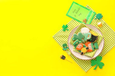 Sarı arka planda Aziz Patrick Günü kutlamaları için lezzetli zencefilli kurabiye tabağı.