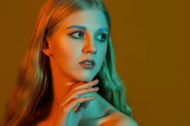 Renkli arka planda sıra dışı kaşları olan güzel bir kız.